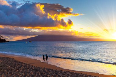 Maui Adası. Çarpıcı Pasifik gün batımı. Okyanus kıyısında romantik bir yürüyüş. Deniz meltemi. Hawaii takımadaları. Polinezya.