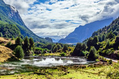 Sığ, sessiz durgun sular. Şili 'ye git. And Dağları bulutlarla kaplı. Meşhur Carretera Austral yolunun çevresi. 