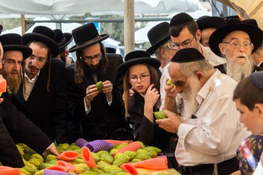 JERUSALEM, ISRAEL - 20 Eylül 2018: Sukkot arifesinde Kudüs 'te tatil öncesi pazar. Fotoğraf turizmi kavramı. Dindar Yahudiler trog 'u seçtiler - muhteşem trenin meyvesi.