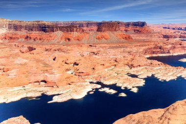 Colorado Nehri. Baraj gölünün kıvrımlı kıyıları kırmızı kumtaşından ve Powell Gölü 'nün parlak mavi suyundan yapılmıştır. Su deposundaki su seviyesinin düşmesine kuraklık neden oldu. ABD