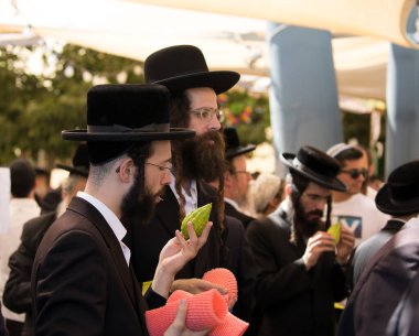 JERUSALEM, ISRAEL - 20 Eylül 2018: Sukkot arifesinde Kudüs 'te tatil öncesi pazar. Genç Yahudiler etrogu seçiyor. Dini, etnografik ve fotoğraf turizmi kavramı