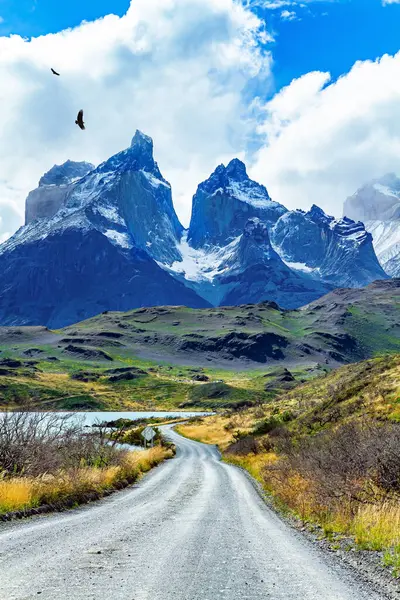 Los Cuernos 'un muhteşem kar kaplı siyah uçurumları. Şili Patagonya 'ya egzotik bir yolculuk. Şili Torres del Paine Ulusal Parkı. Toprak yol Pehoe Gölü kıyısından geçiyor.