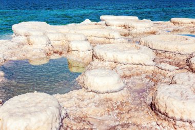 Tuz kristallerinin yuvarlak oluşumları. Tuz kristalizasyonunun resim gibi bir sonucu. Sıcak bir günde ünlü deniz. İsrail. Orta Doğu 'daki Ölü Deniz. 