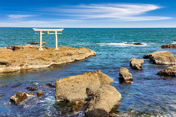 Resimli kayalık Pasifik kıyısı. Oarai Isosaki Tapınağı 'nın torii kapısı. Tanrıların Kıyısı 'na geçit. Tapınak, Japonya 'yı yaratan iki kutsal tanrının onuruna inşa edildi.