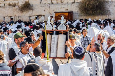 JERUSALEM, ISRAEL - 26 Eylül 2018: Yahudiler, tallitlere sarılı olarak Batı Duvarı 'nda dua ediyorlar. Sukkot. Dindar Yahudiler kutsal Tevrat Parşömenleri taşırlar. Dini turizm konsepti. 