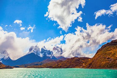 Los Cuernos 'un muhteşem kar kaplı siyah uçurumları. Lago Pehoe. Torres del Paine Ulusal Parkı. Eriyen buzulların suyu parlak bir gök mavisi rengine sahiptir. Chiles Patagonya