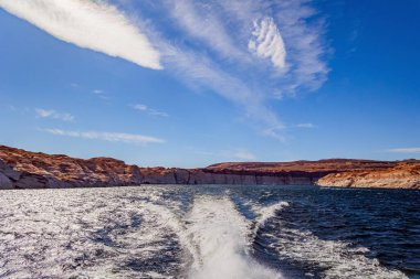 Powell Gölü 'nde tekne gezisi. Tekne arkasında beyaz bir köpük izi bırakıyor. Güzel, güneşli, sıcak bir gün. Powell Gölü yapay bir rezervuar. Colorado Nehri. ABD.