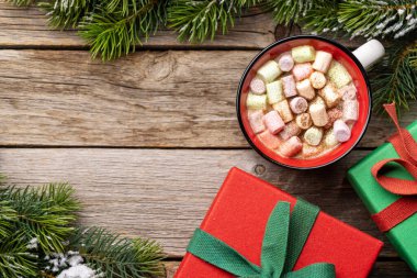 Marshmallow ve xmas hediye kutularıyla dolu bir fincan. Fotokopi alanı olan Noel tatili