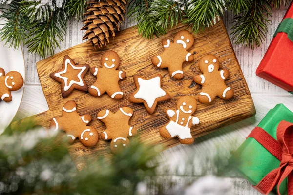 ジンジャーブレッドマンは木の板でクッキーを作る クリスマス休暇のギフトボックス — ストック写真
