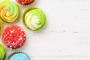 Ahşap arka planda renkli kekler ve fotokopi alanı. Düz yatıyordu