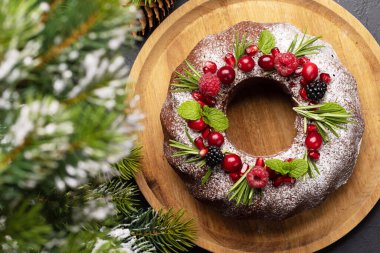 Nar tohumları, kızılcık ve biberiyeyle süslenmiş Noel pastası. Düz yatıyordu