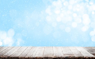 Kış bokeh arka planlı bir Noel masası. Ürününüzü göstermek için