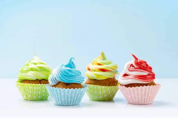 Colorful cupcakes on blue background