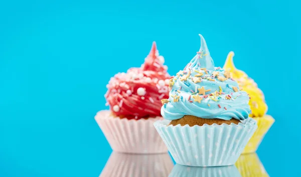 Colorful cupcakes on blue background