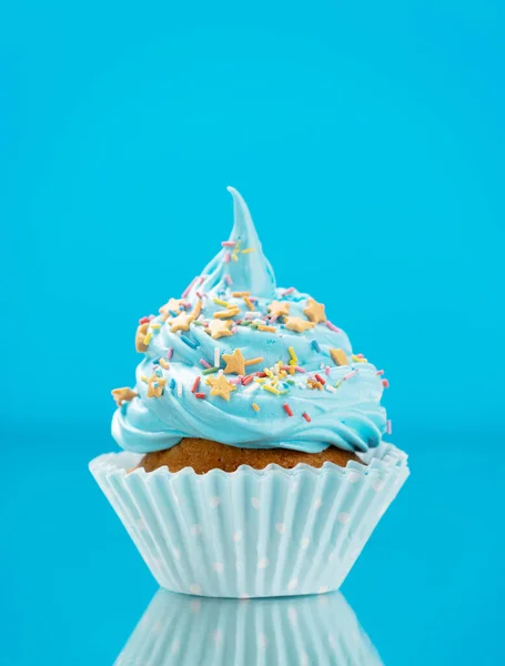 Blue cupcake on blue background with copy space