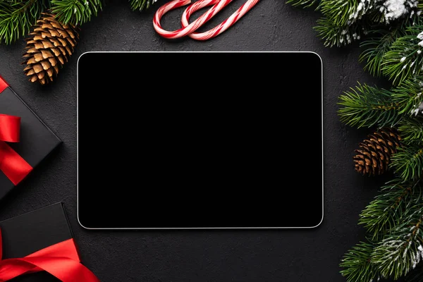 Tablet with blank screen, gift boxes and Christmas decor. Xmas device screen template