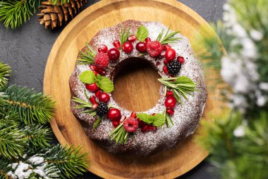 Nar tohumları, kızılcık ve biberiyeyle süslenmiş Noel pastası. Düz yatıyordu