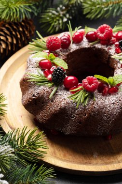 Nar tohumları, kızılcık ve biberiyeyle süslenmiş Noel pastası.