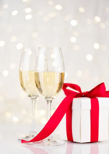 Champagnergläser Und Geschenkbox Vor Der Weihnachtsbeleuchtung Bokeh — Stockfoto
