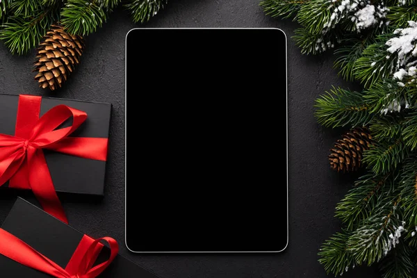 Tablet with blank screen, gift boxes and Christmas decor. Xmas device screen template