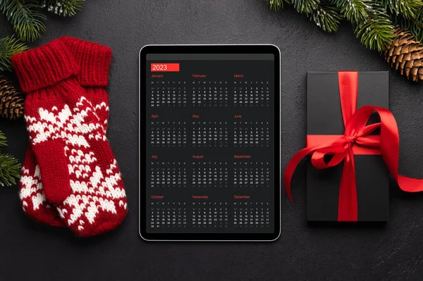 Tablet with next year calendar, gift boxes and Christmas decor. Xmas device screen template