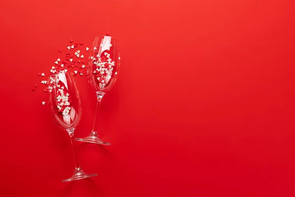 シャンパングラスとハート型のお菓子付きバレンタインデーカード あなたの挨拶のためのスペースと赤の背景に — ストック写真