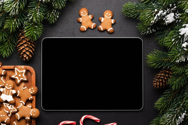 Tablet with blank screen, gingerbread cookies and Christmas decor. Xmas device screen template