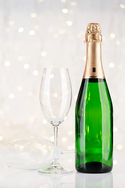 在圣诞灯前的香槟瓶和玻璃杯 — 图库照片