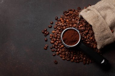 Kavrulmuş kahve çekirdeği ve filtre tutacağında öğütülmüş kahve. Üst görünüm düzlüğü kopyalama alanı ile yatıyordu
