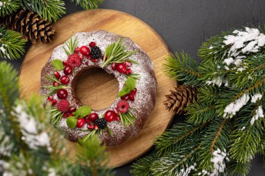 Nar tohumları, kızılcık ve biberiyeyle süslenmiş Noel pastası. Kopyalama alanı olan düz