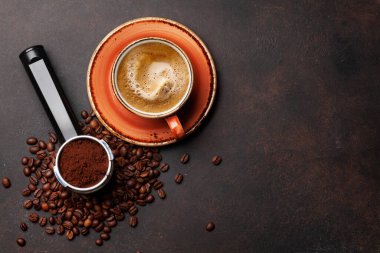 Kavrulmuş kahve çekirdekleri, filtre tutacağında öğütülmüş kahve ve espresso fincanı. Üst görünüm düzlüğü kopyalama alanı ile yatıyordu