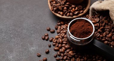 Kavrulmuş kahve çekirdeği ve filtre tutacağında öğütülmüş kahve. Kopyalama alanı ile