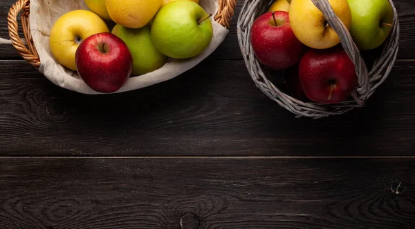 木製のテーブルの上にバスケットにカラフルな熟したリンゴの果物 コピースペース付きのトップビューフラットレイ — ストック写真