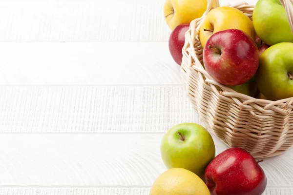 木製のテーブルの上にバスケットにカラフルな熟したリンゴの果物 コピースペース付き — ストック写真