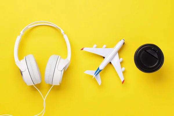 旅行和度假的概念 黄色桌子上的耳机 咖啡和飞机 — 图库照片