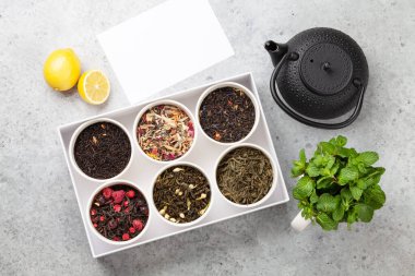 Kutuda çeşitli kurutulmuş çaylar. Bitki, yeşil ve siyah çay yaprakları. Üst görünüm düzlüğü kopyalama alanı ile yatıyordu