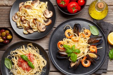 Çeşitli İtalyan makarnaları. Deniz ürünleri, mantar ve domates soslu makarna, spagetti bolonez. Üst görünüm düzlüğü