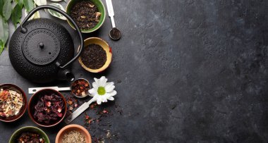 Çeşitli kurutulmuş çay ve çaydanlık. Üst görünüm düzlüğü kopyalama alanı ile yatıyordu