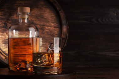 Bardak ve şişe konyak, viski ya da altın rom. Kopya alanı olan eski ahşap fıçının önünde.