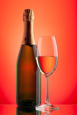 Şampanya bardağı ve köpüklü şarap şişesi