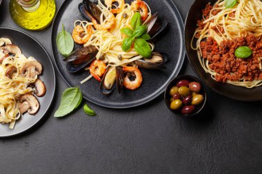 Çeşitli İtalyan makarnaları. Deniz ürünleri, mantar ve domates soslu makarna, spagetti bolonez. Üst görünüm düzlüğü kopyalama alanı ile yatıyordu