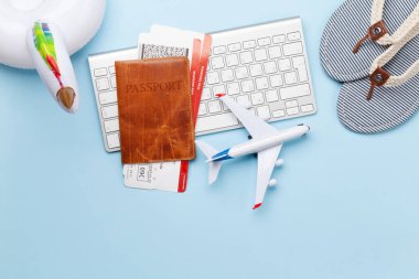 Seyahat ve tatil konsepti. Aksesuarlar ve eşyalar. Biletli pasaport, klavye ve uçak oyuncağı. Üst görünüm düzlüğü