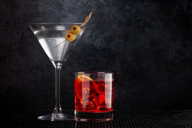 Negroni ve martini kokteylleri koyu arkaplanda fotokopi alanı ile