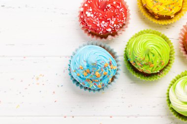 Ahşap masada renkli kekler. Kopyalama alanı olan düz