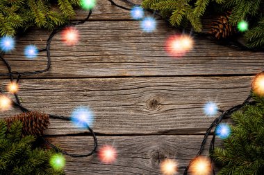 Noel tatili arka planı, süslü Noel ağacı ve çelenkleri olan ahşap masa. Kopyalama alanı olan düz