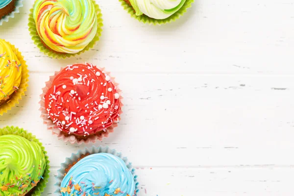 Ahşap masada renkli kekler. Kopyalama alanı olan düz