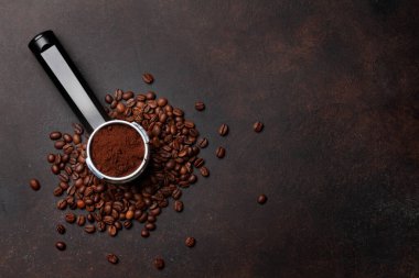 Kavrulmuş kahve çekirdeği ve filtre tutacağında öğütülmüş kahve. Üst görünüm düzlüğü kopyalama alanı ile yatıyordu