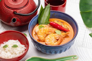 Tayland Tom Yum Çorbası, deniz mahsulü ve bir kase pirinç.