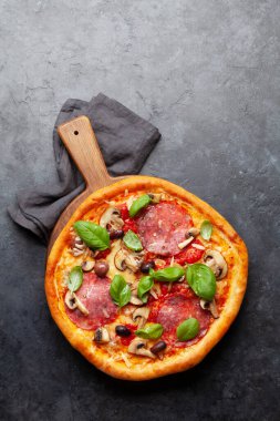 İtalyan mutfağı. Pepperoni pizza. Fotokopi alanı olan taş masanın üzerine yatıyordu.