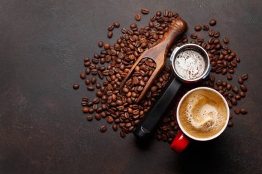 Kavrulmuş kahve çekirdekleri, filtre tutacağında öğütülmüş kahve ve espresso fincanı. Üst görünüm düzlüğü kopyalama alanı ile yatıyordu
